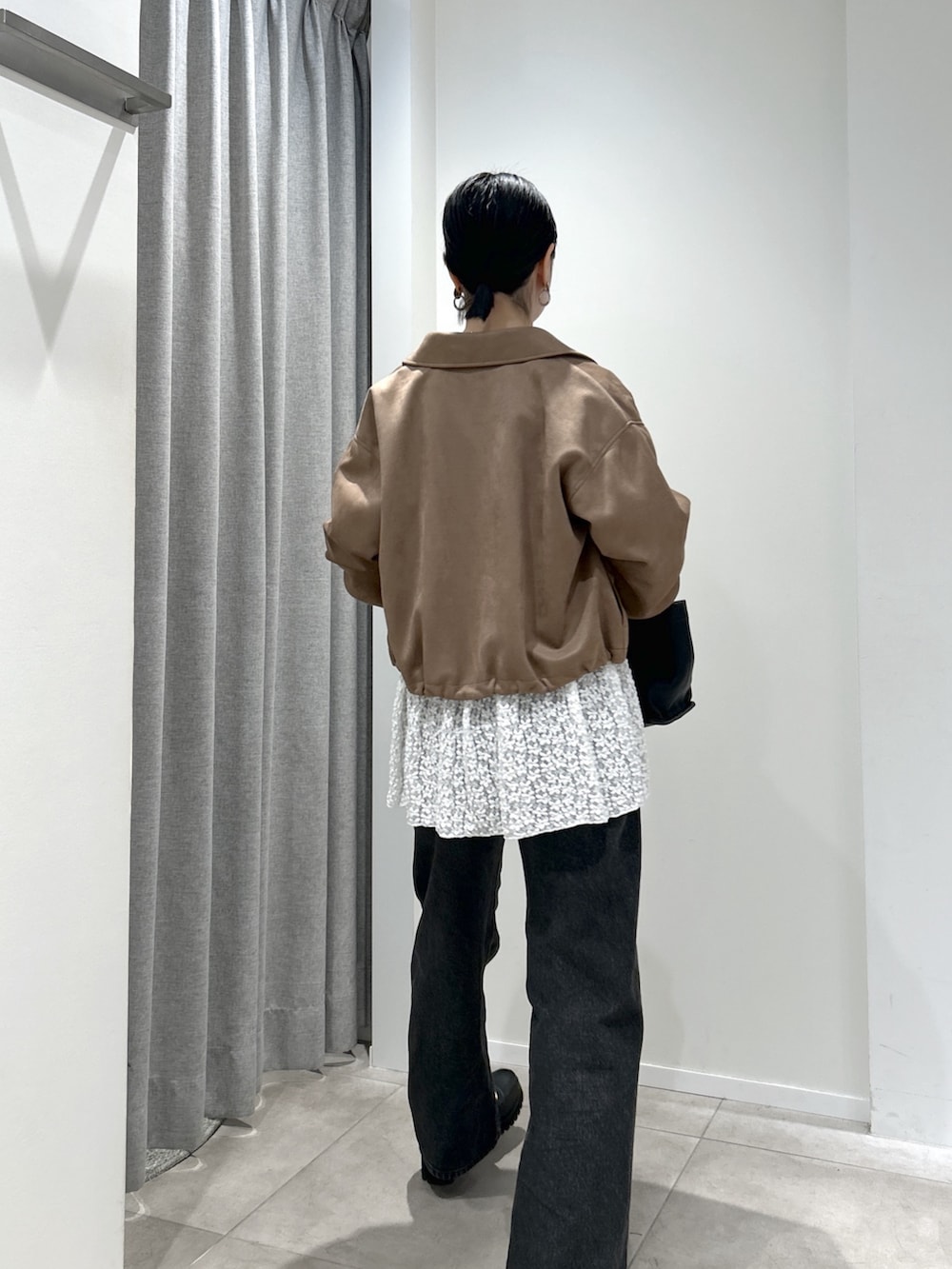 イエロー系のブルゾン、ホワイト系のTシャツ/カットソー、ブラック系のデニムパンツを着用したレディースの秋コーディネートの3枚目の写真