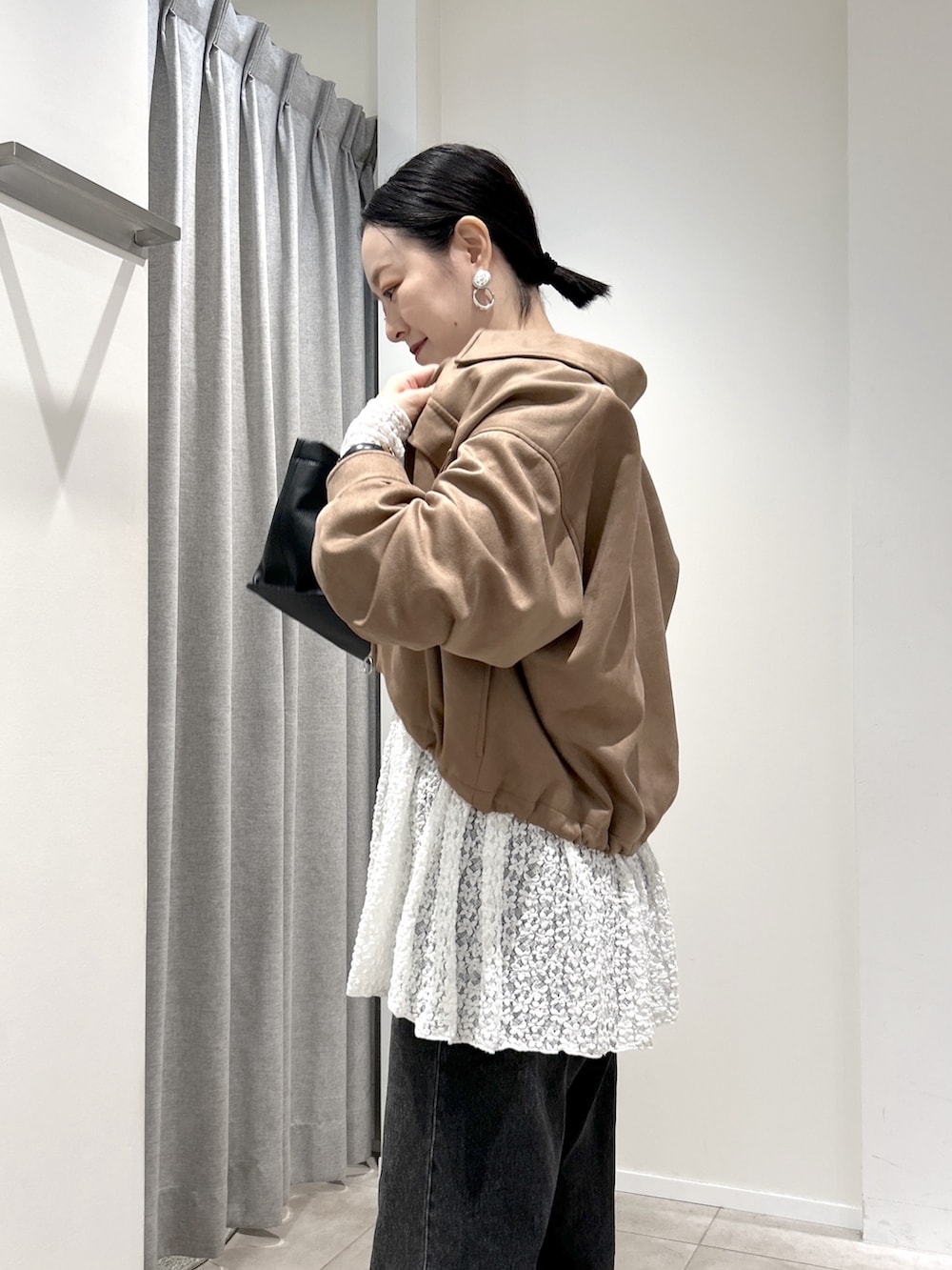 イエロー系のブルゾン、ホワイト系のTシャツ/カットソー、ブラック系のデニムパンツを着用したレディースの秋コーディネートの4枚目の写真