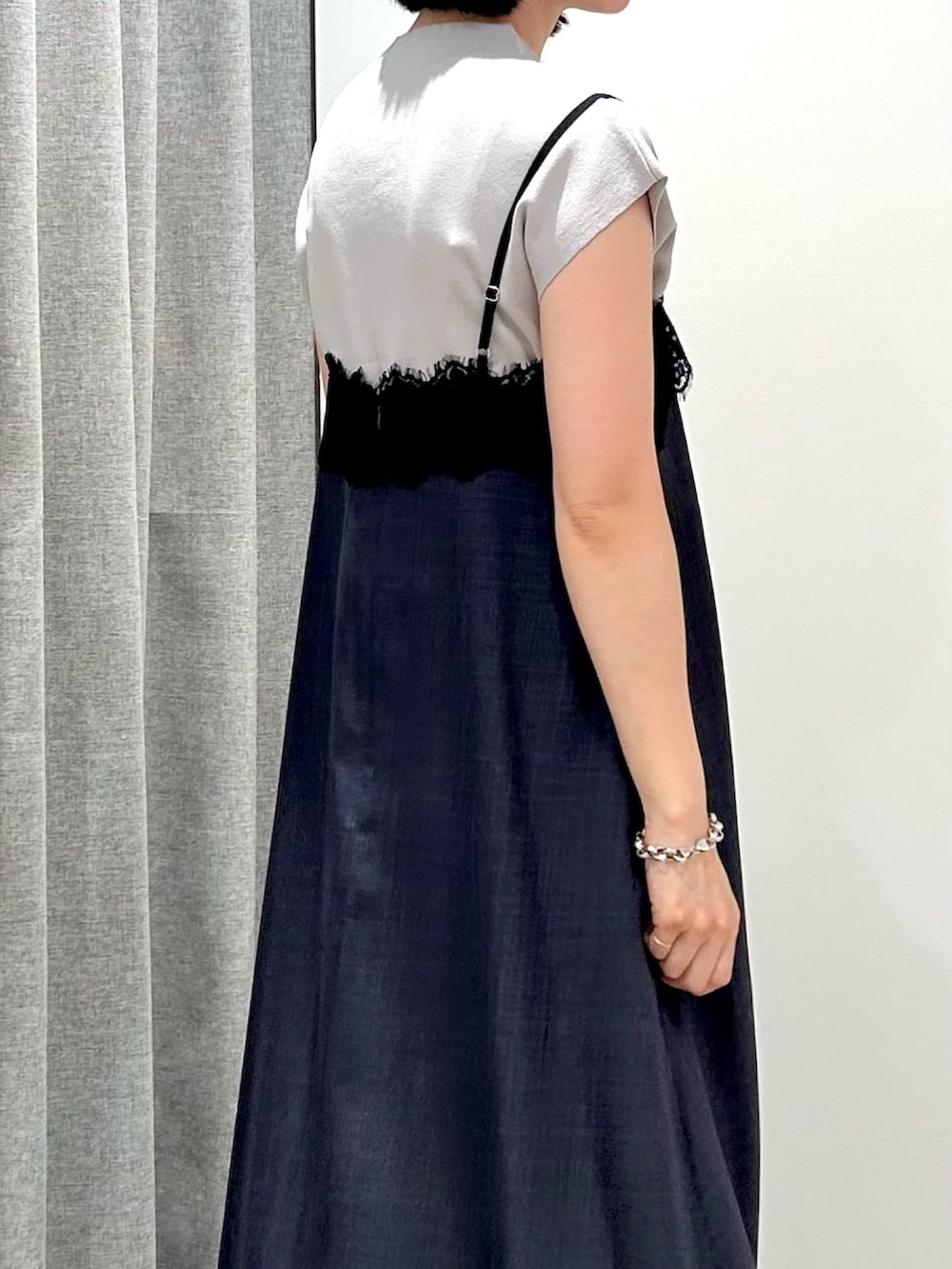 グレー系のワンピース、ベージュ系のニット/セーター、ブラウン系のボストンバッグを着用したレディースの夏コーディネートの7枚目の写真
