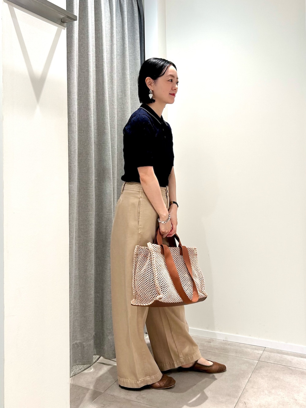 ブルー系のポロシャツ、イエロー系のその他パンツ、イエロー系のトートバッグを着用したレディースの夏コーディネートの4枚目の写真
