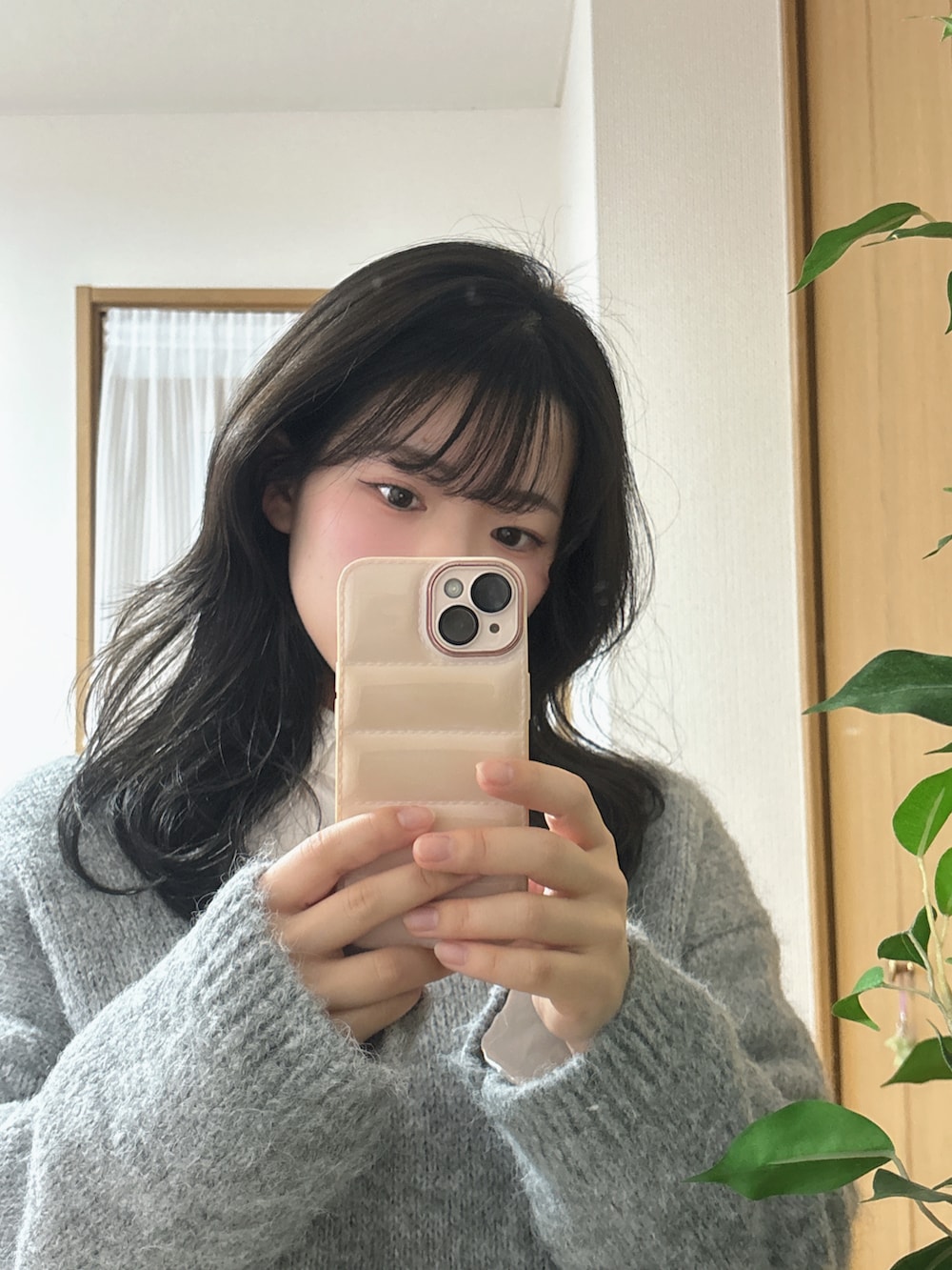 グレー系のニット/セーター、ブルー系のデニムパンツを着用したレディースの冬コーディネートの4枚目の写真