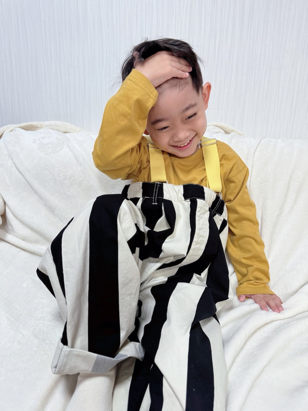 イエロー系のTシャツ/カットソー、ホワイト系のサロペット/オーバーオールを着用したキッズの冬コーディネートの3枚目の写真