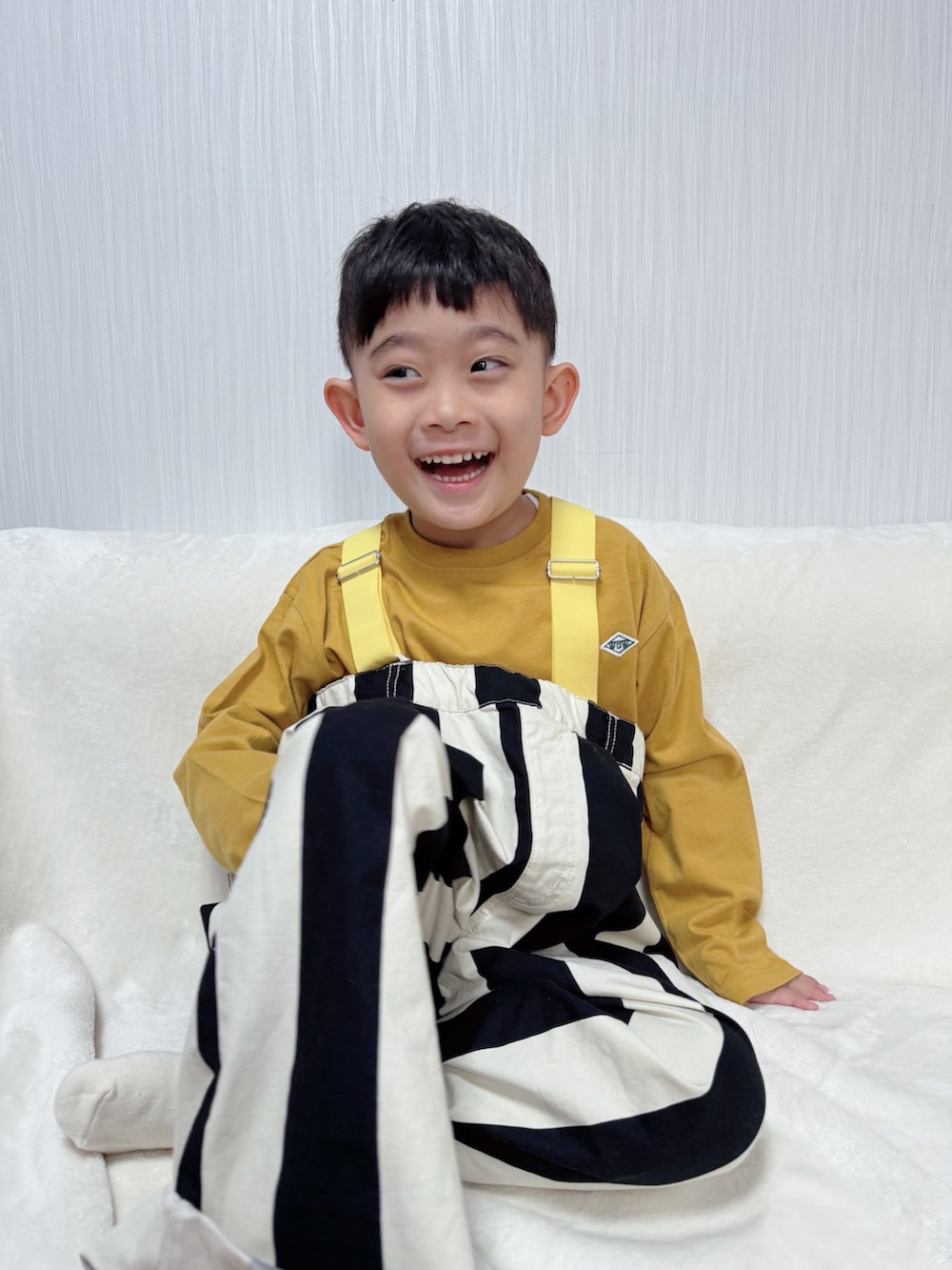 イエロー系のTシャツ/カットソー、ホワイト系のサロペット/オーバーオールを着用したキッズの冬コーディネートの2枚目の写真