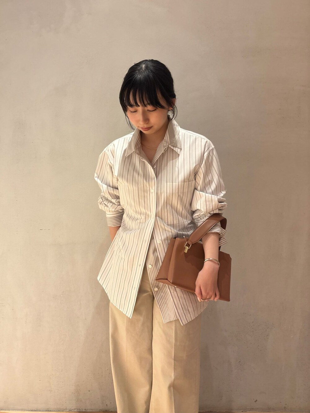ベージュ系のデニムパンツ、イエロー系のシャツ/ブラウス、ベージュ系のシャツ/ブラウスを着用したレディースの冬コーディネートの3枚目の写真