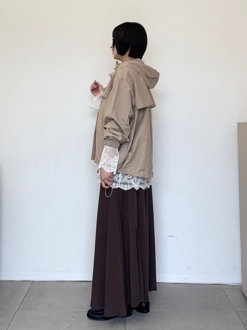 ベージュ系のマウンテンパーカー、ホワイト系のシャツ/ブラウス、ブラウン系のスカートを着用したレディースの秋コーディネートの2枚目の写真