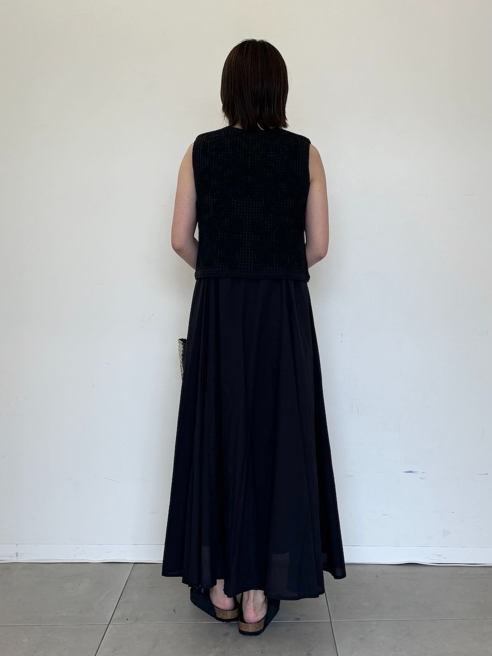 ブラック系のワンピース、ブラック系のシャツ/ブラウス、ブルー系のトートバッグを着用したレディースの夏コーディネートの2枚目の写真