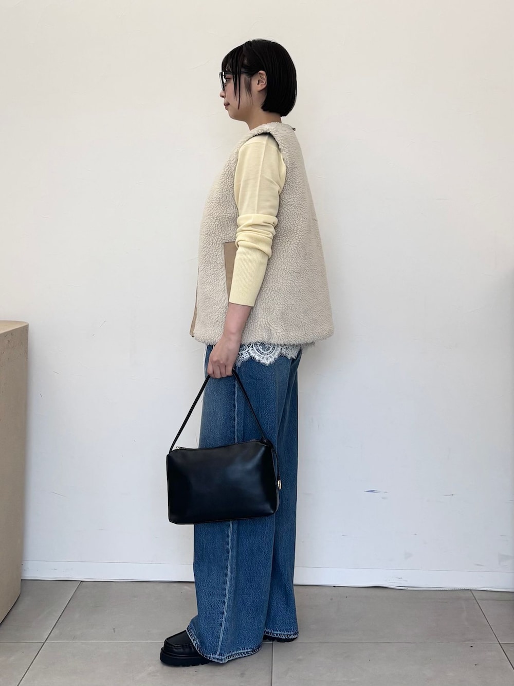 ホワイト系のその他アウター、ブルー系のデニムパンツ、イエロー系のニット/セーターを着用したレディースの秋コーディネートの3枚目の写真