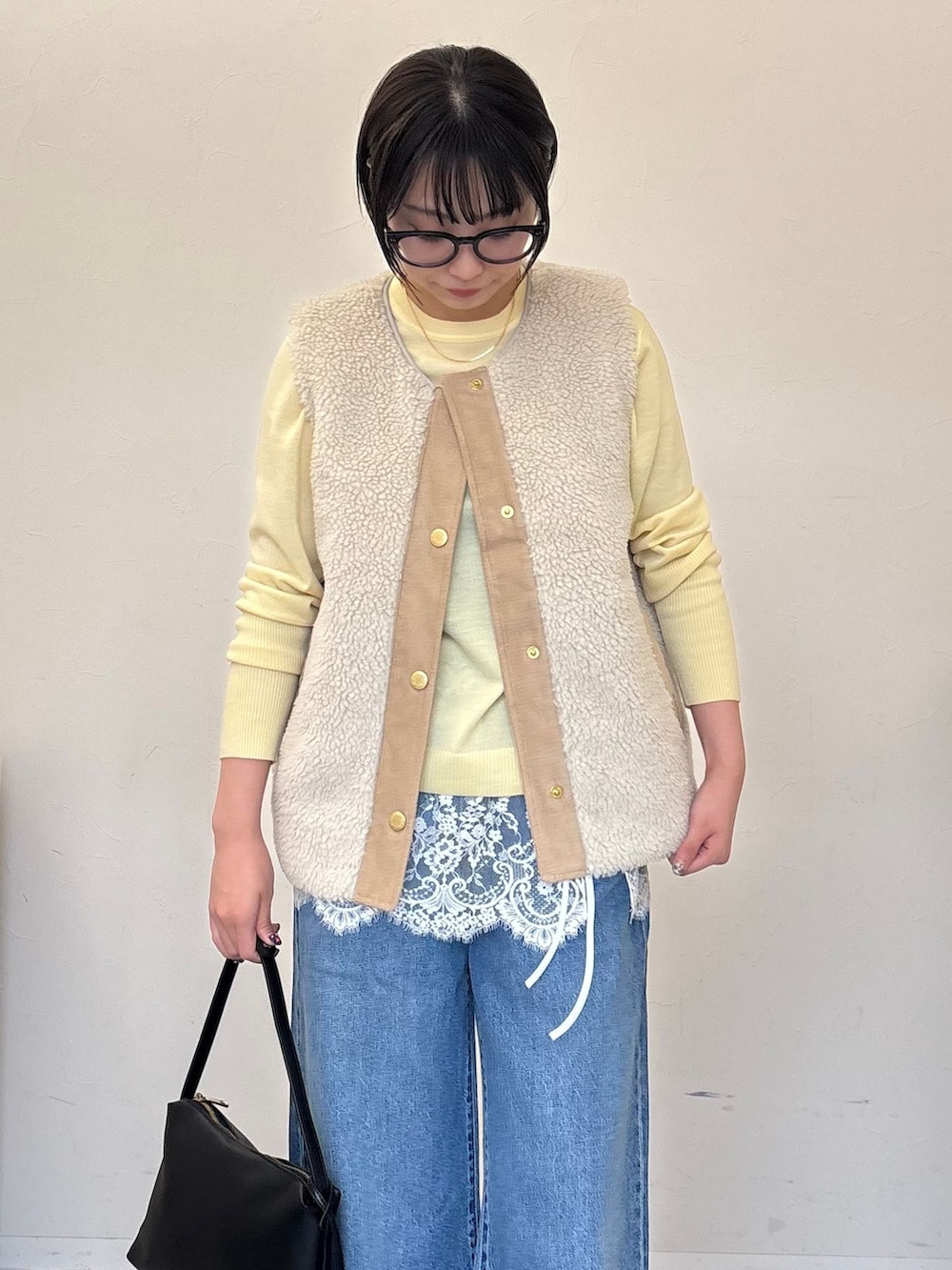 ホワイト系のその他アウター、ブルー系のデニムパンツ、イエロー系のニット/セーターを着用したレディースの秋コーディネートの2枚目の写真