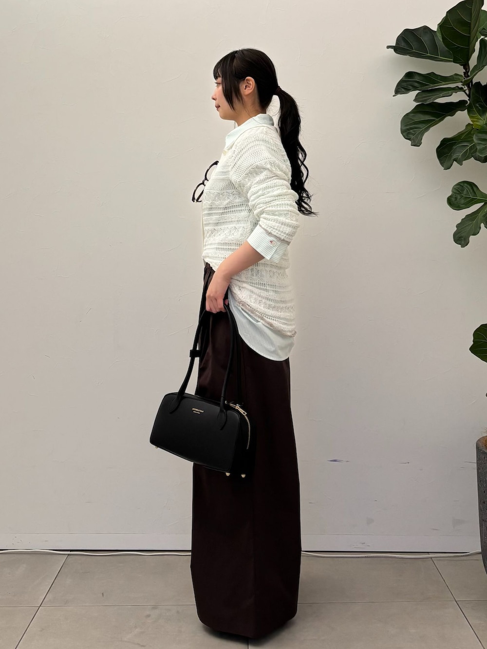 ブラウン系のその他パンツ、グリーン系のシャツ/ブラウス、ホワイト系のニット/セーターを着用したレディースの春コーディネートの2枚目の写真