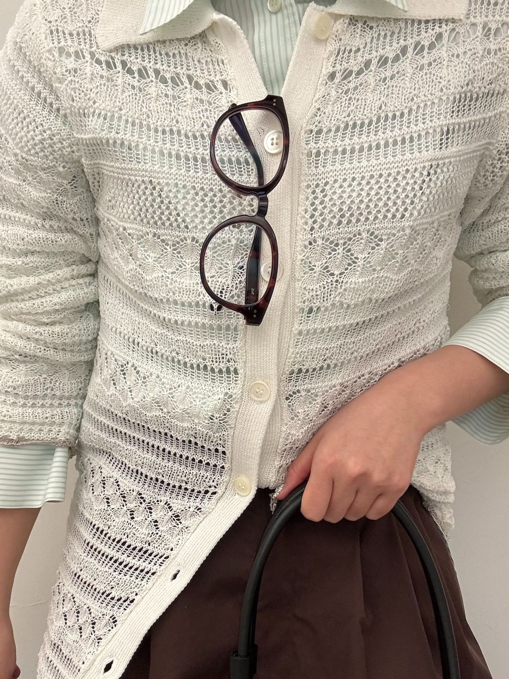 ブラウン系のその他パンツ、グリーン系のシャツ/ブラウス、ホワイト系のニット/セーターを着用したレディースの春コーディネートの4枚目の写真