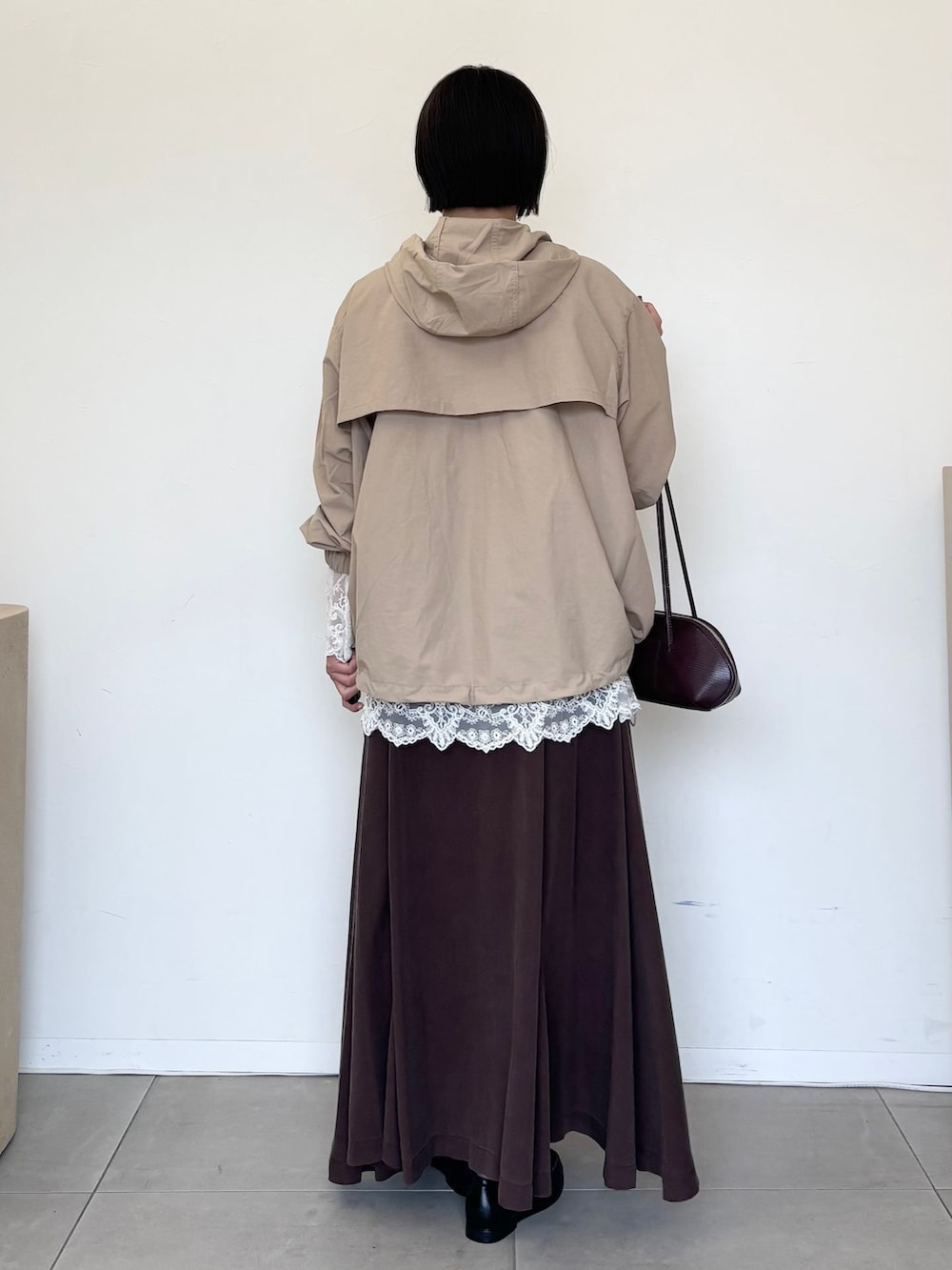 ベージュ系のマウンテンパーカー、ホワイト系のシャツ/ブラウス、ブラウン系のスカートを着用したレディースの秋コーディネートの3枚目の写真