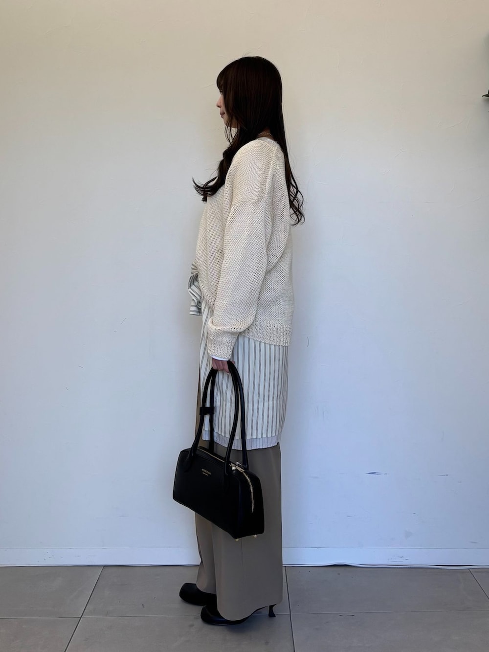 ベージュ系のスラックス、ベージュ系のシャツ/ブラウス、ホワイト系のTシャツ/カットソーを着用したレディースの春コーディネートの2枚目の写真