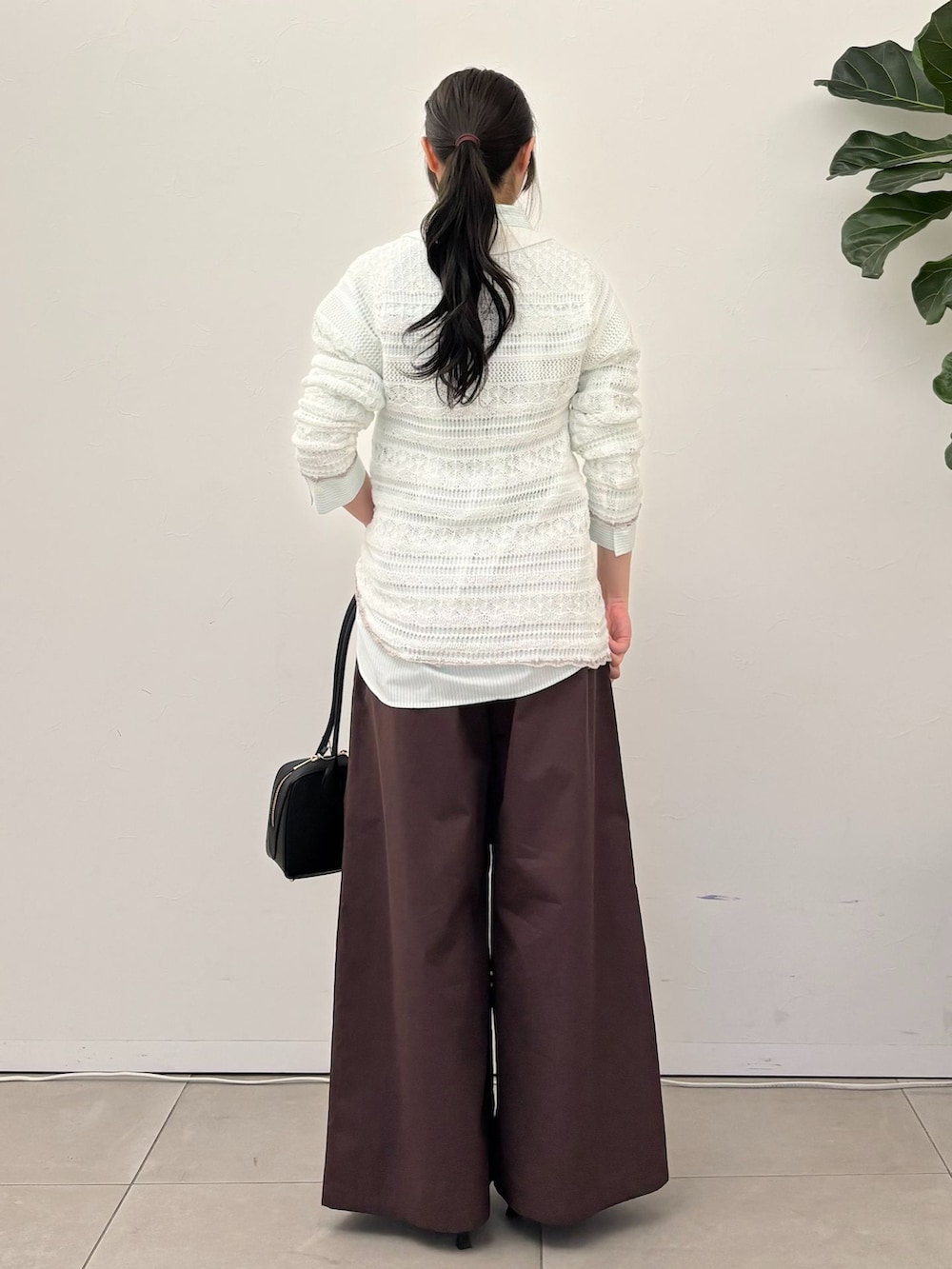 ブラウン系のその他パンツ、グリーン系のシャツ/ブラウス、ホワイト系のニット/セーターを着用したレディースの春コーディネートの3枚目の写真