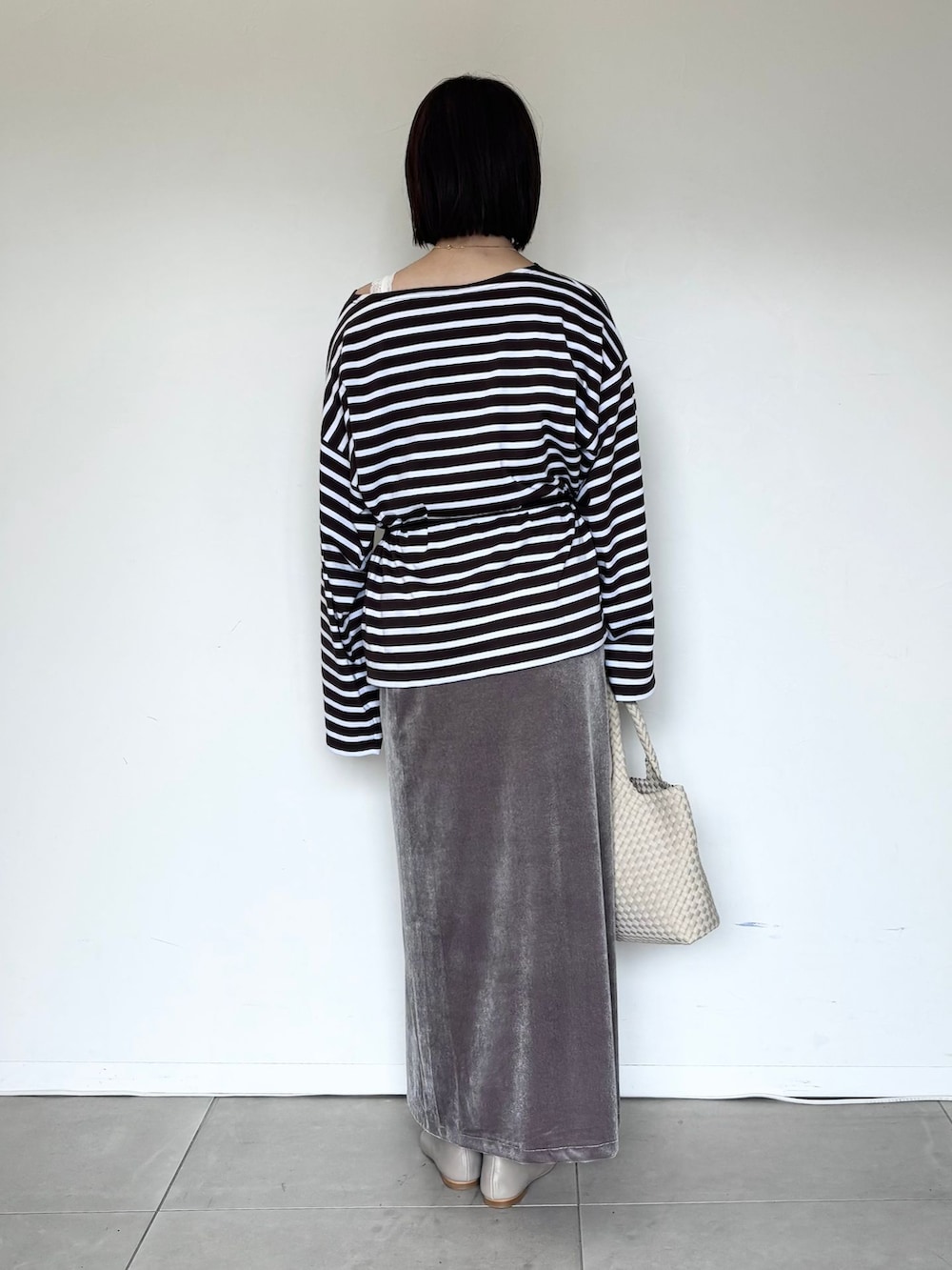 グレー系のスカート、ホワイト系のタンクトップ、ブラウン系のTシャツ/カットソーを着用したレディースの夏コーディネートの3枚目の写真