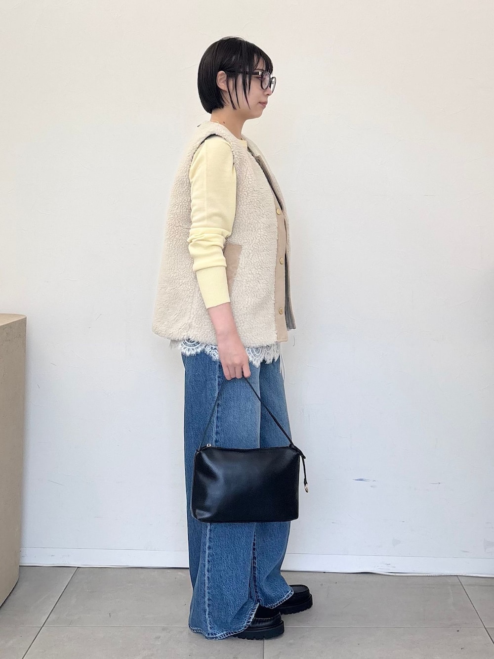 ホワイト系のその他アウター、ブルー系のデニムパンツ、イエロー系のニット/セーターを着用したレディースの秋コーディネートの5枚目の写真