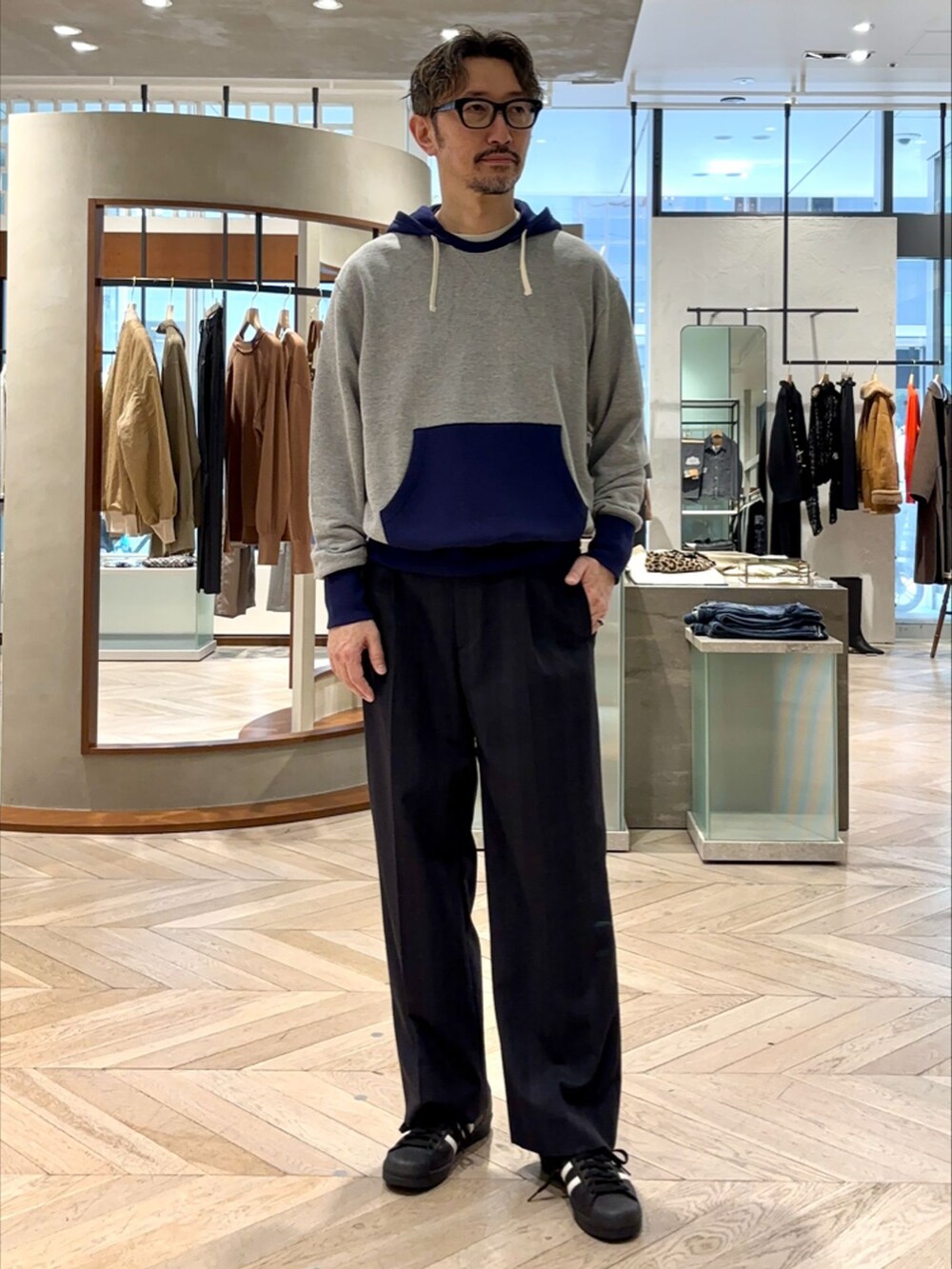 ブルー系のスラックス、その他のパーカー、ブラック系のスニーカーを着用したメンズの秋コーディネートの2枚目の写真