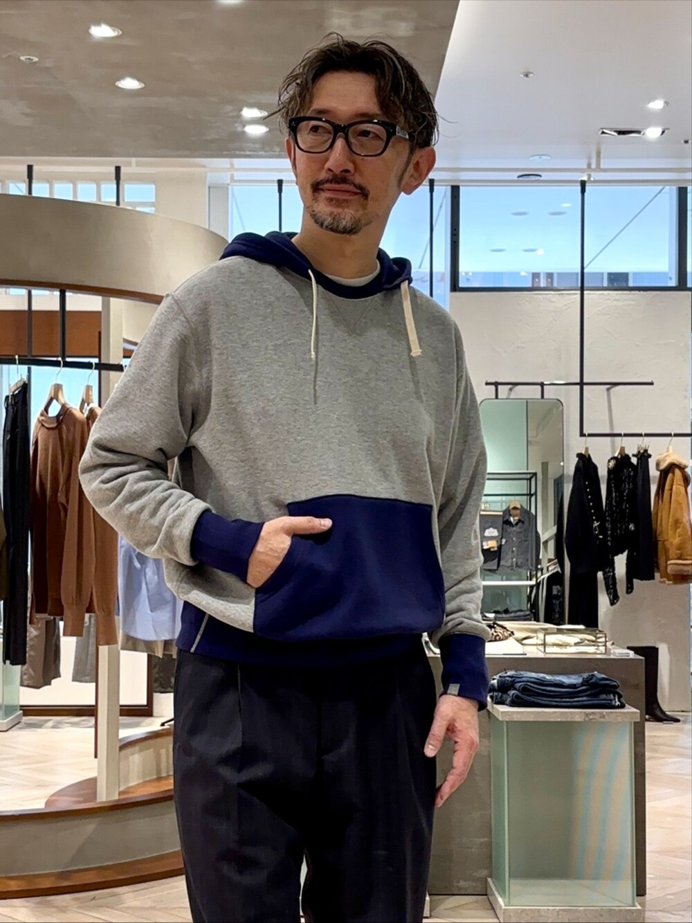 ブルー系のスラックス、その他のパーカー、ブラック系のスニーカーを着用したメンズの秋コーディネートの3枚目の写真