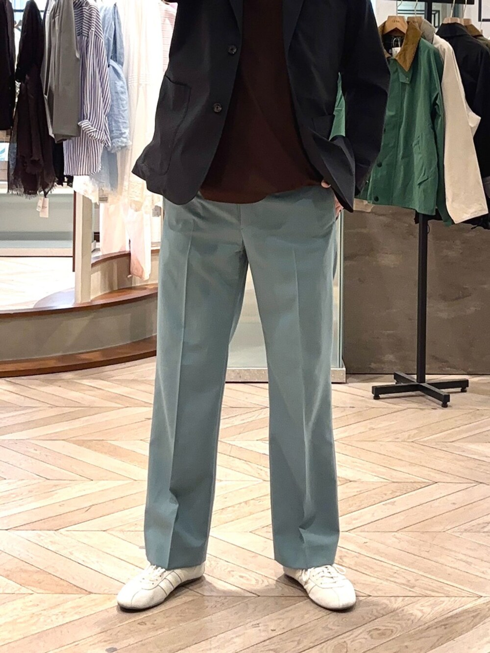 ブラック系のテーラードジャケット、グリーン系のスラックス、ブラウン系のTシャツ/カットソーを着用したメンズの春コーディネートの5枚目の写真
