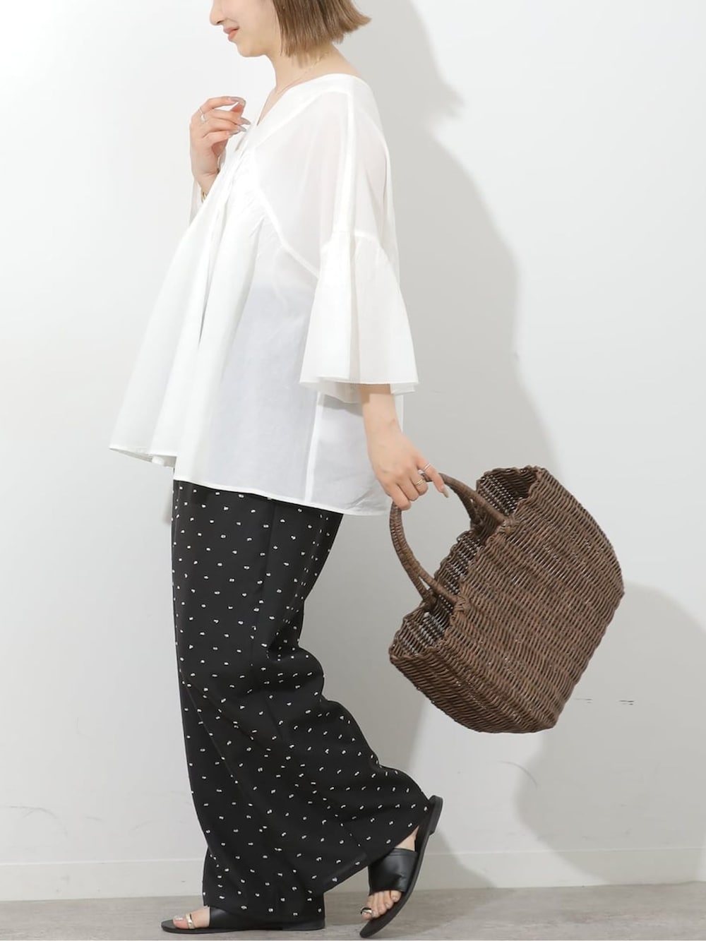 ブラック系のその他パンツ、ホワイト系のシャツ/ブラウス、ブラウン系のかごバッグを着用したレディースの夏コーディネートの3枚目の写真