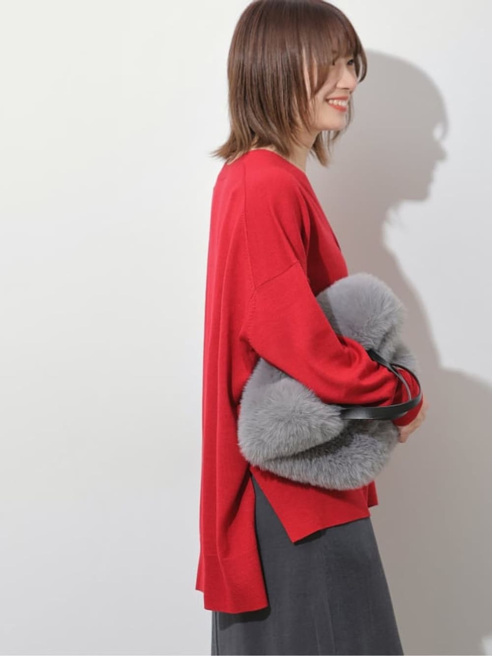 グレー系のスカート、レッド系のカーディガン/ボレロ、グレー系のハンドバッグを着用したレディースの夏コーディネートの5枚目の写真