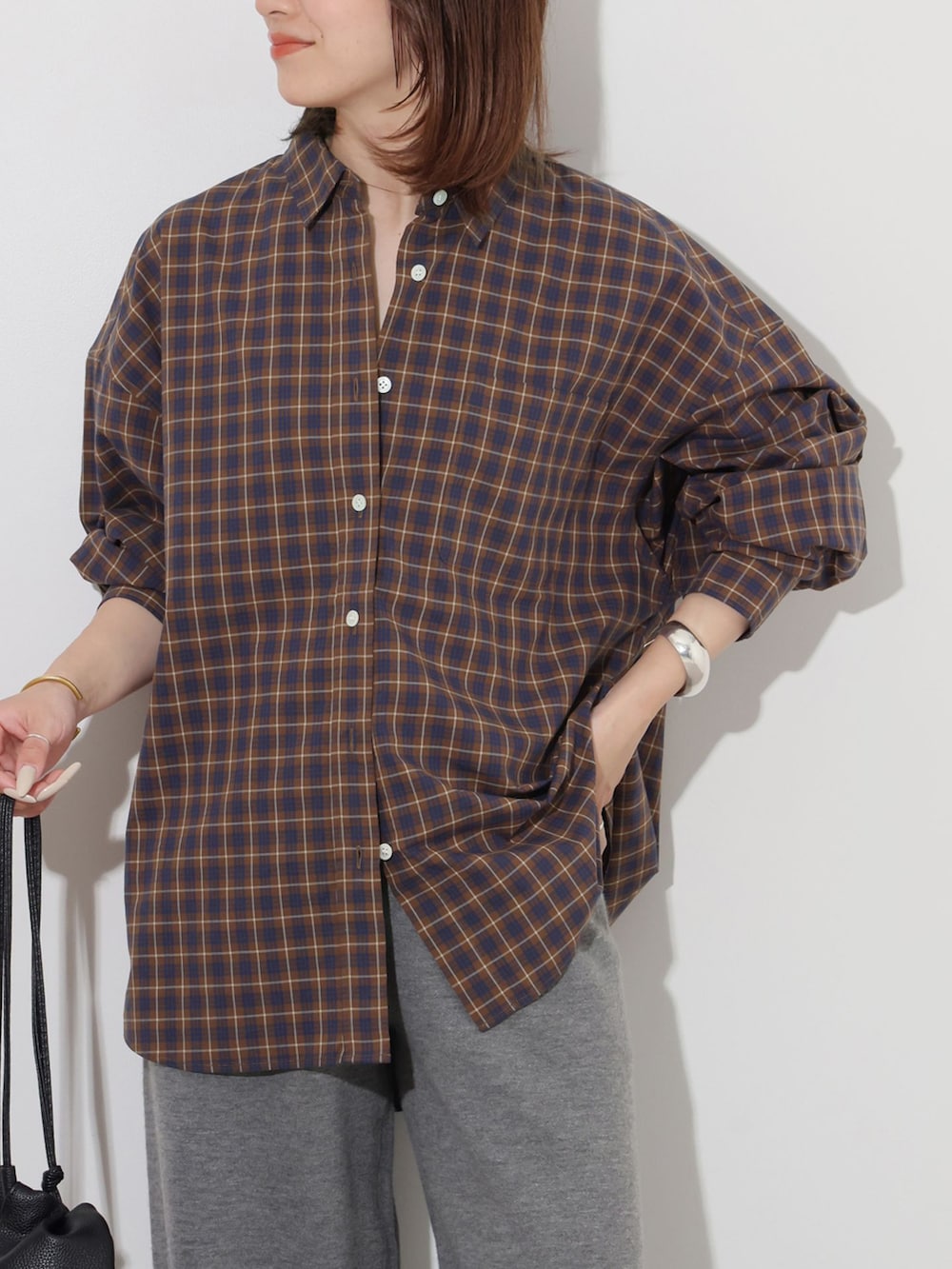 ブラウン系のシャツ/ブラウス、グレー系のその他パンツ、ブラック系のショルダーバッグを着用したレディースの秋コーディネートの4枚目の写真
