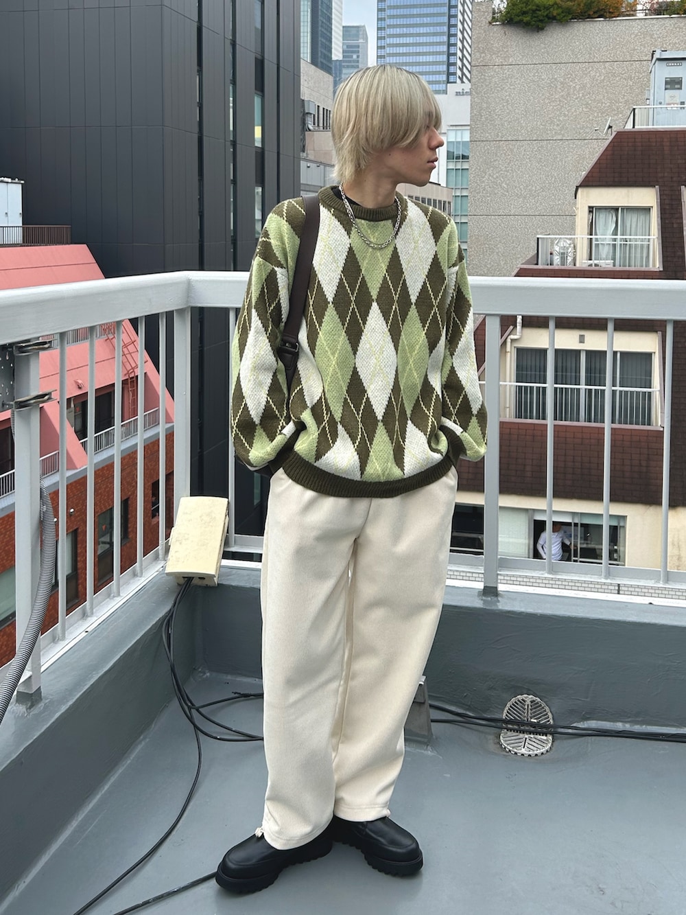 グリーン系のニット/セーター、ホワイト系のその他パンツ、ブラウン系のショルダーバッグを着用したメンズの冬コーディネートの2枚目の写真