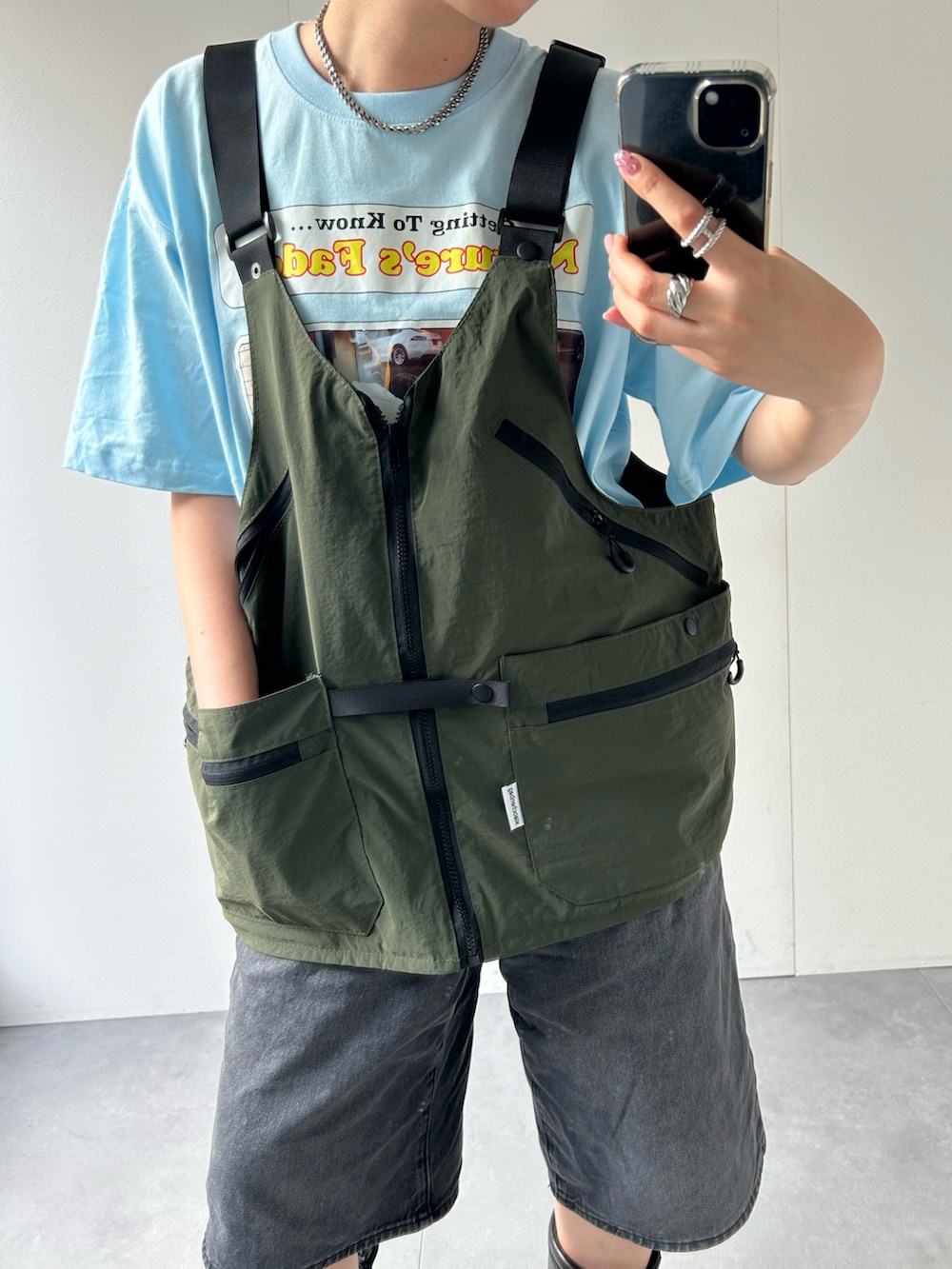 グリーン系のベストを着用したレディースの春コーディネートの6枚目の写真