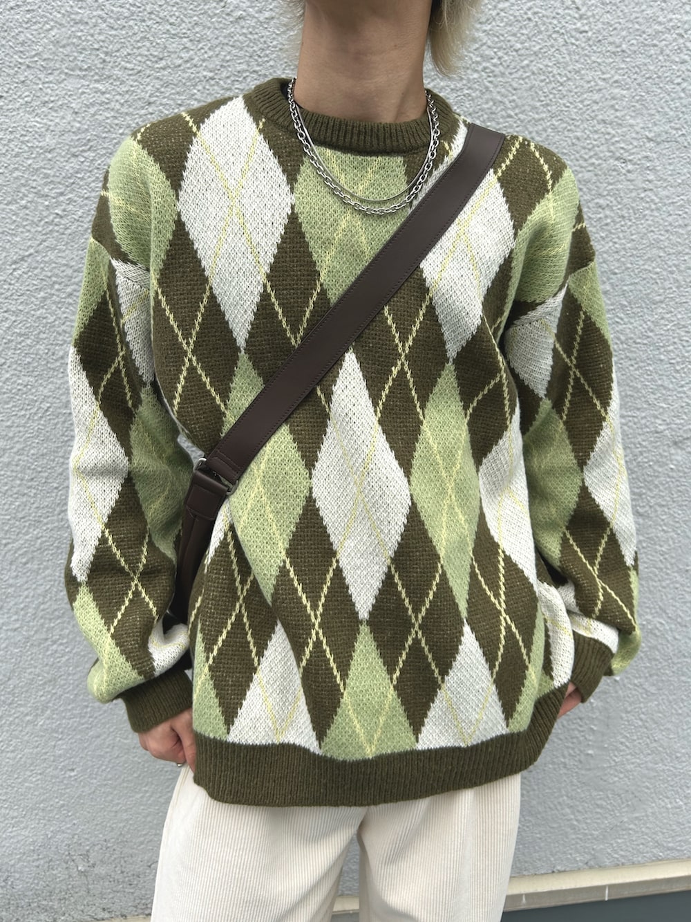 グリーン系のニット/セーター、ホワイト系のその他パンツ、ブラウン系のショルダーバッグを着用したメンズの冬コーディネートの5枚目の写真