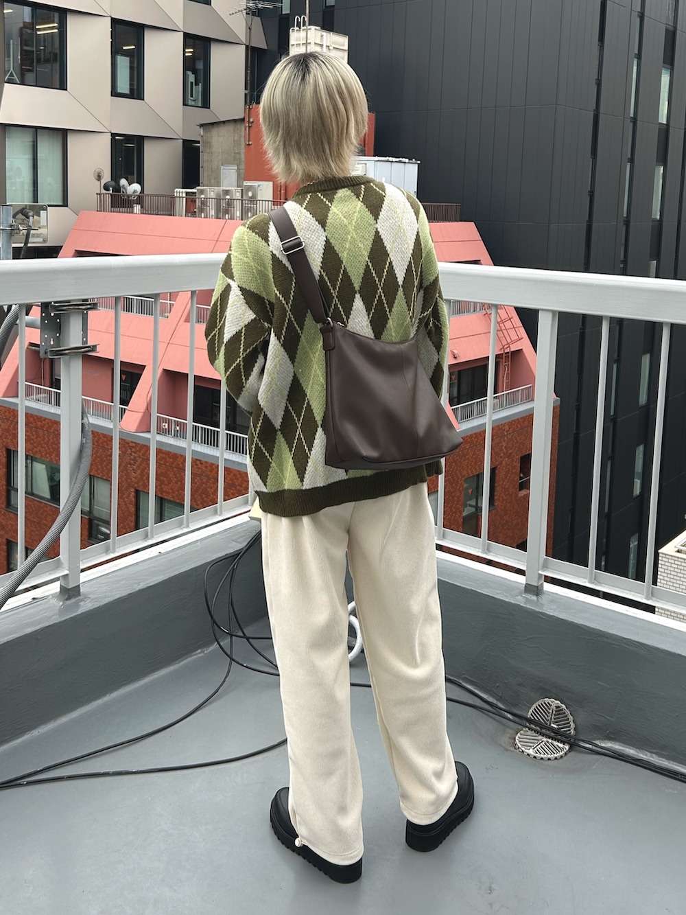 グリーン系のニット/セーター、ホワイト系のその他パンツ、ブラウン系のショルダーバッグを着用したメンズの冬コーディネートの3枚目の写真