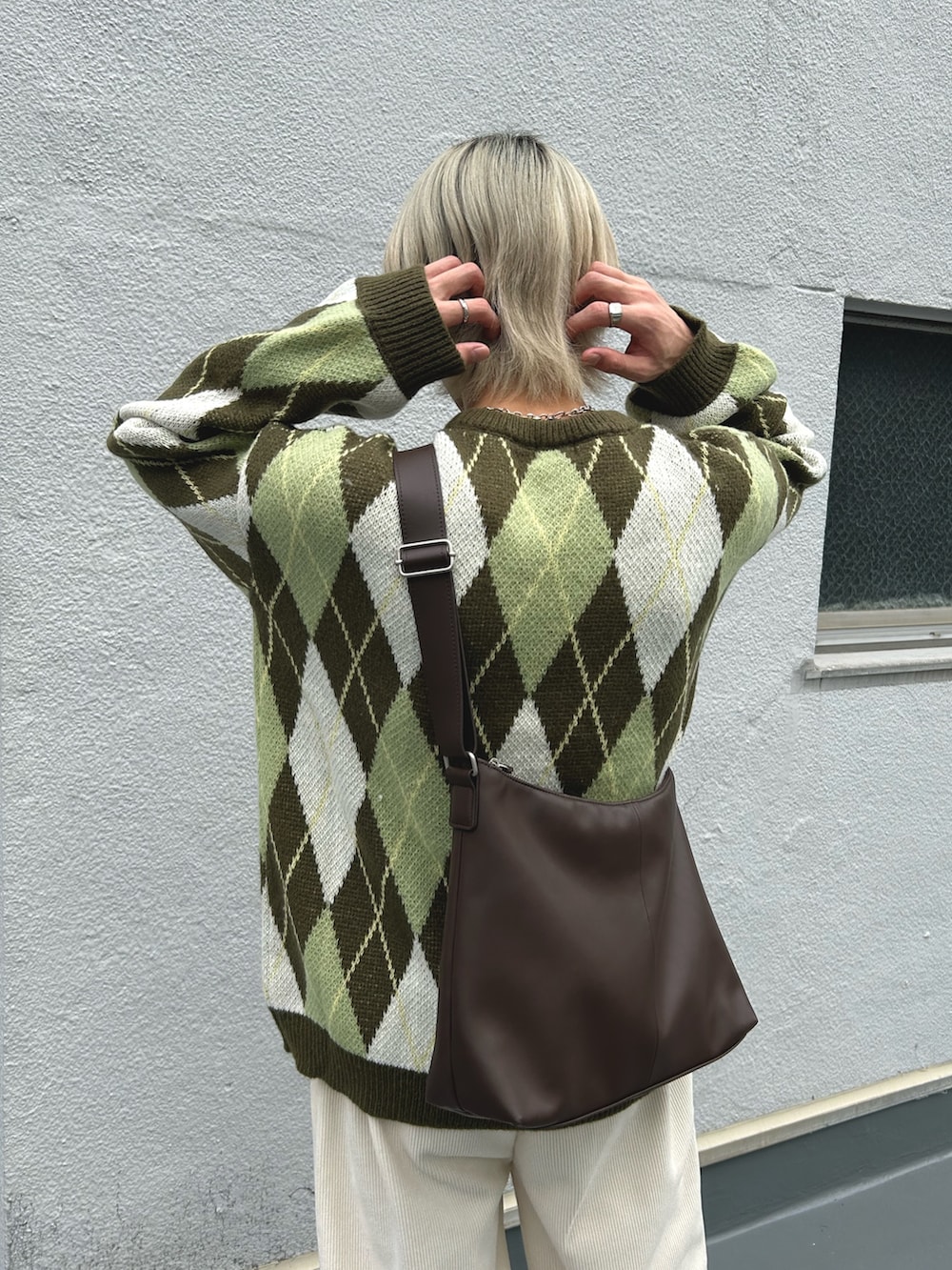 グリーン系のニット/セーター、ホワイト系のその他パンツ、ブラウン系のショルダーバッグを着用したメンズの冬コーディネートの4枚目の写真