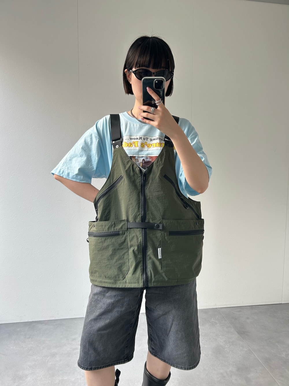グリーン系のベストを着用したレディースの春コーディネートの3枚目の写真
