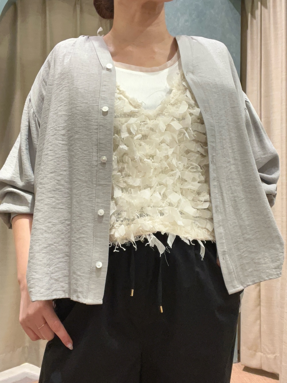 グレー系のシャツ/ブラウス、ブラック系のその他パンツ、ホワイト系のベストを着用したレディースの春コーディネートの2枚目の写真