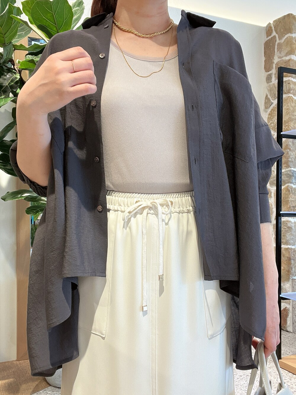 グレー系のタンクトップ、グレー系のシャツ/ブラウス、ホワイト系のトートバッグを着用したレディースの春コーディネートの2枚目の写真
