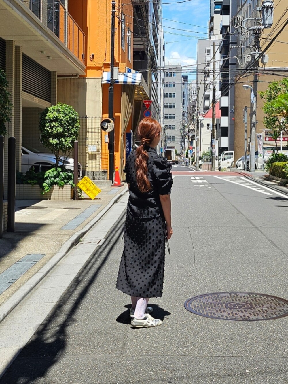 シルバー系のスニーカー、ブラック系のシャツ/ブラウス、ブラック系のスカートを着用したレディースの夏コーディネートの2枚目の写真