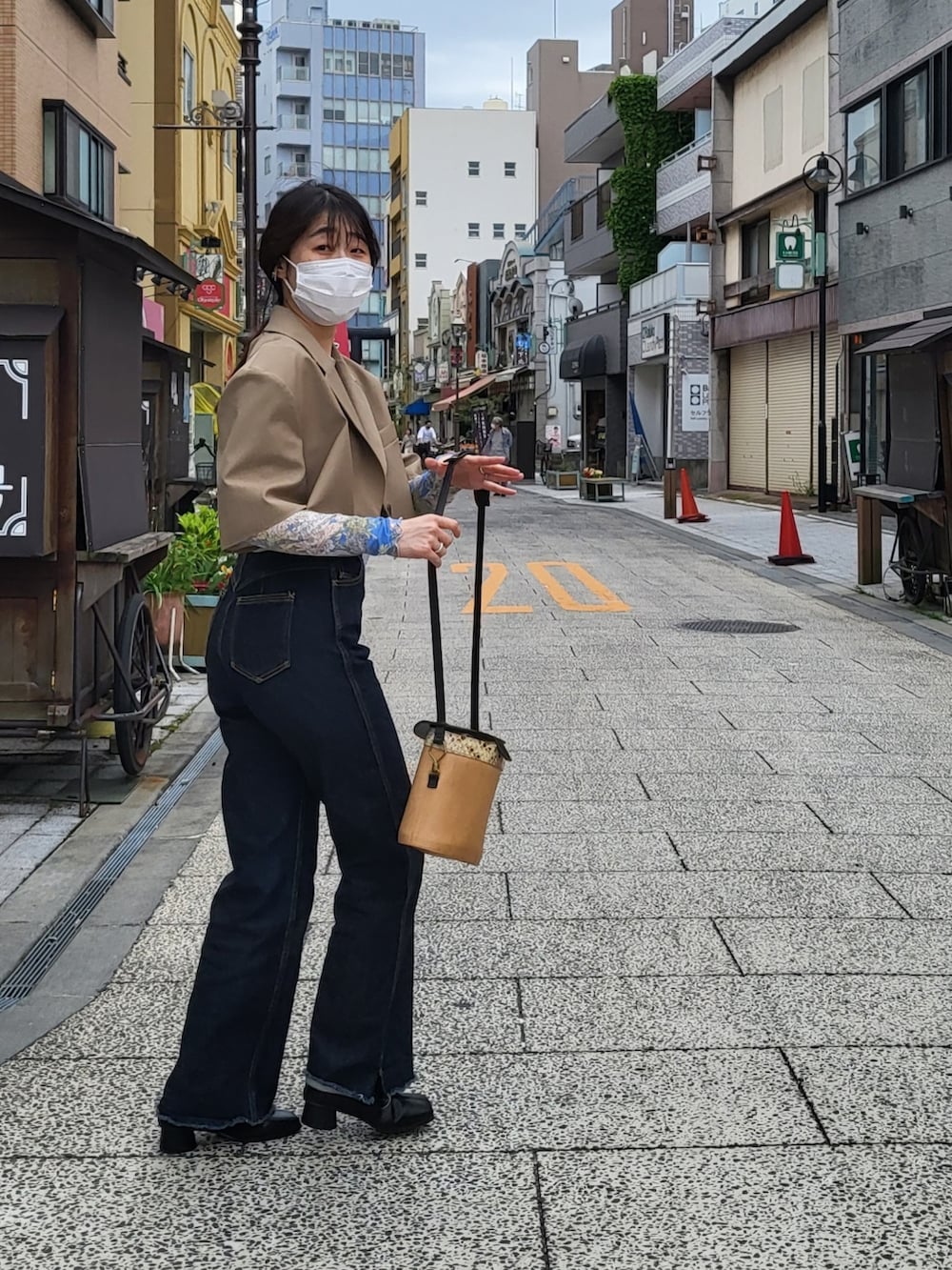 ブルー系のデニムパンツ、ブラック系のブーツ、ブルー系のトップスを着用したレディースの春コーディネートの3枚目の写真