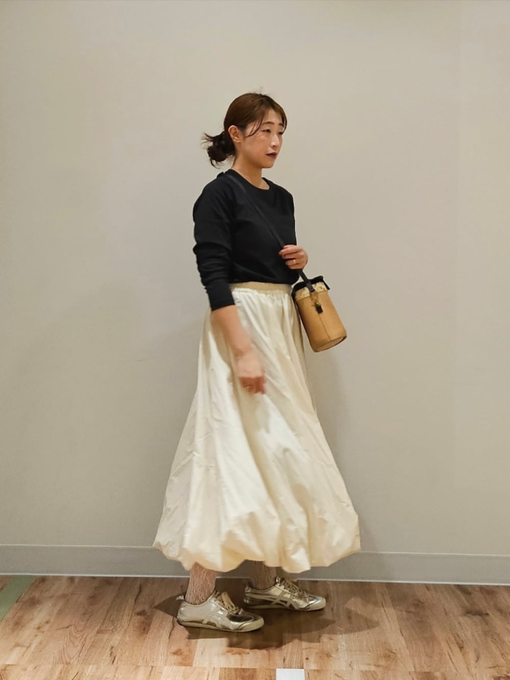 シルバー系のスニーカー、ブラック系のTシャツ/カットソー、その他のバッグを着用したレディースの秋コーディネートの2枚目の写真