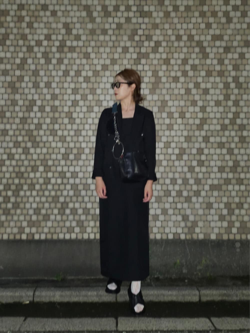 ブラック系のテーラードジャケット、ブラック系のワンピース、ブラック系のサンダルを着用したレディースの秋コーディネートの2枚目の写真