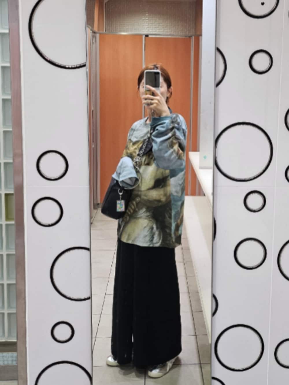 その他のTシャツ/カットソー、ブラック系のスカート、ブラック系のハンドバッグを着用したレディースの秋コーディネートの2枚目の写真