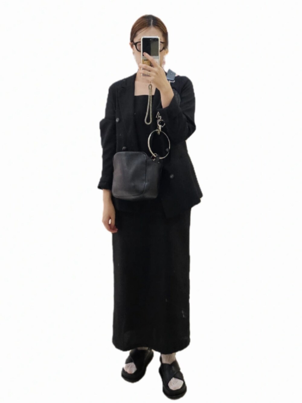 ブラック系のテーラードジャケット、ブラック系のワンピース、ブラック系のサンダルを着用したレディースの秋コーディネートの3枚目の写真