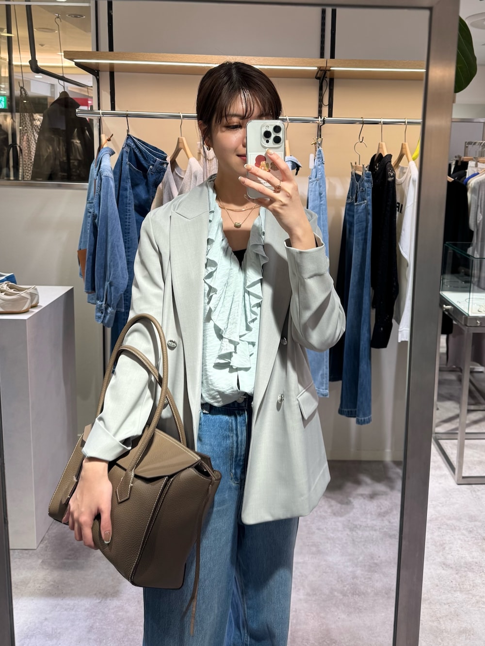 ブルー系のシャツ/ブラウス、ブラウン系のトートバッグ、グレー系のテーラードジャケットを着用したレディースの冬コーディネートの3枚目の写真