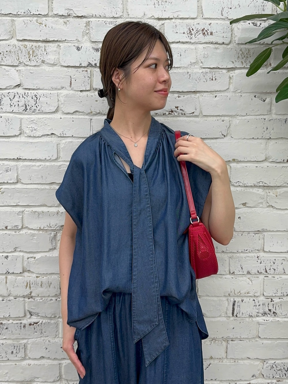 ブルー系のシャツ/ブラウス、ブルー系のその他パンツ、レッド系のハンドバッグを着用したレディースの夏コーディネートの2枚目の写真