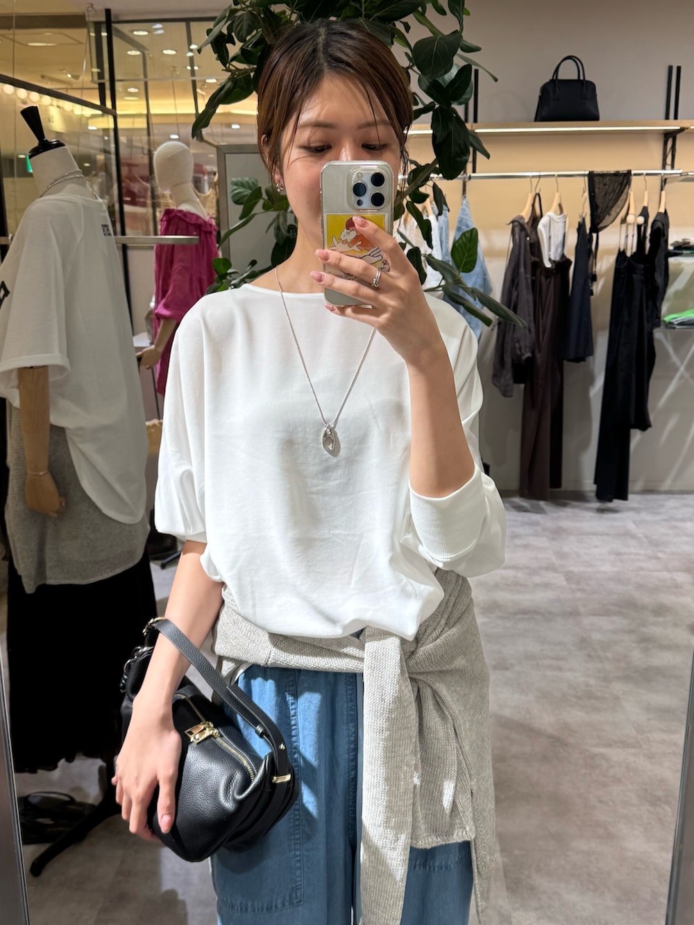 ホワイト系のシャツ/ブラウス、ブルー系のデニムパンツ、ブラック系のショルダーバッグを着用したレディースの夏コーディネートの2枚目の写真