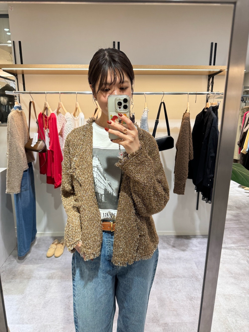 ホワイト系のTシャツ/カットソー、ベージュ系のカーディガン/ボレロ、ブルー系のデニムパンツを着用したレディースの秋コーディネートの2枚目の写真