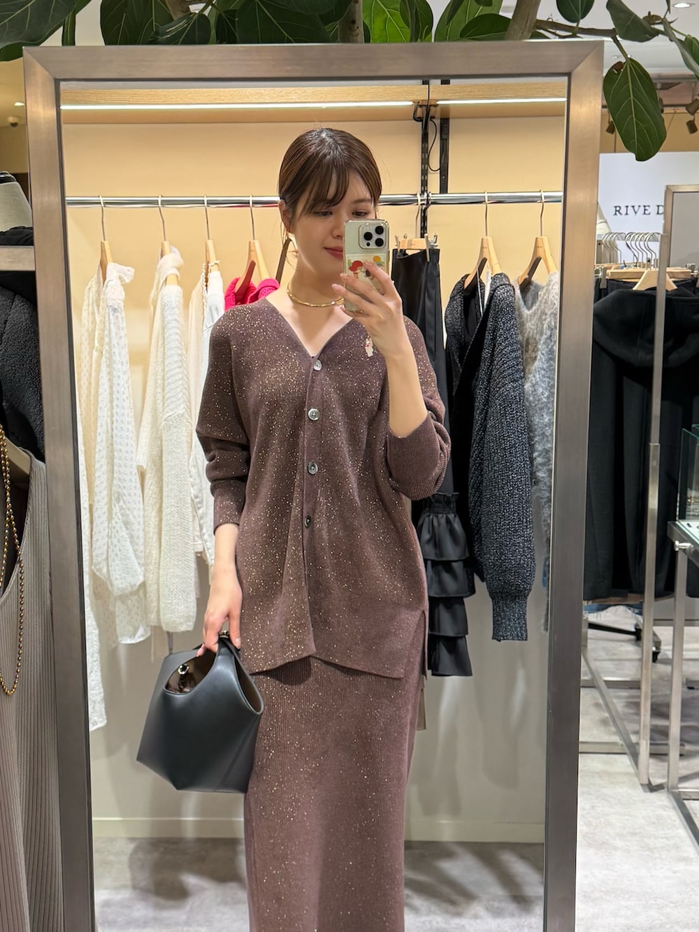 ブラウン系のニット/セーター、ブラウン系のスカートを着用したレディースの冬コーディネートの2枚目の写真