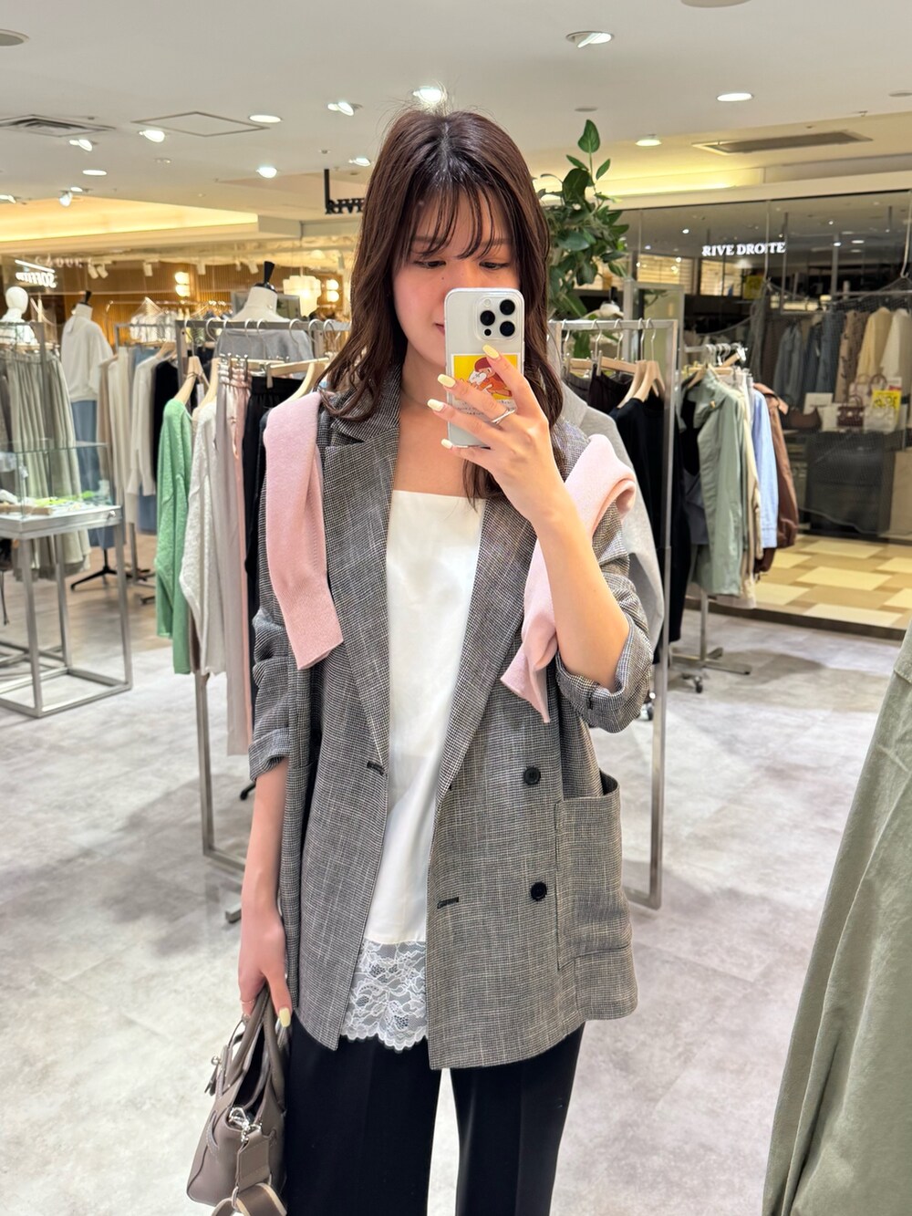 ブラック系のテーラードジャケット、ブラック系のその他パンツ、ホワイト系のキャミソールを着用したレディースの春コーディネートの2枚目の写真