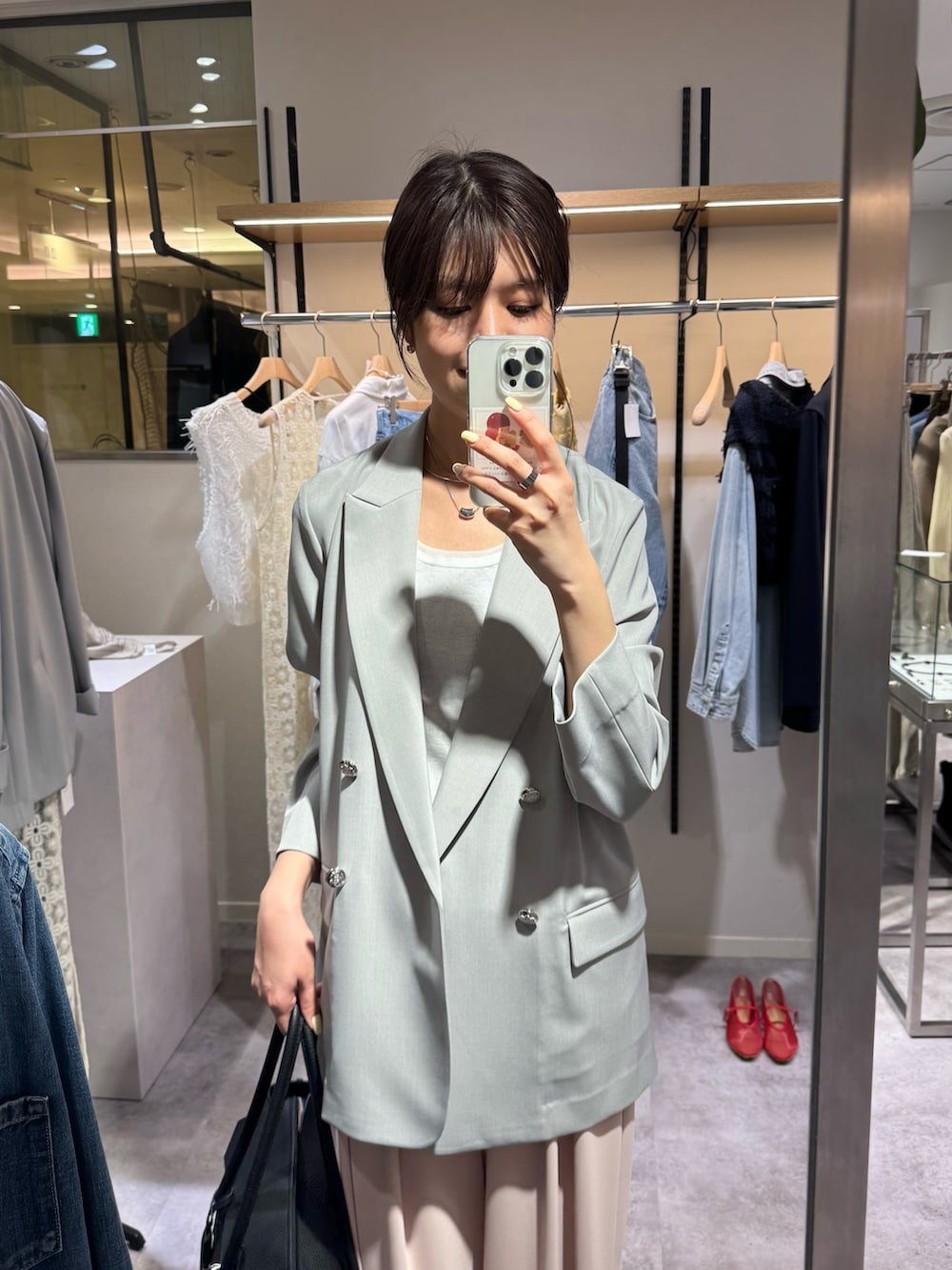 グレー系のテーラードジャケット、ホワイト系のキャミソール、ピンク系のスラックスを着用したレディースの春コーディネートの2枚目の写真