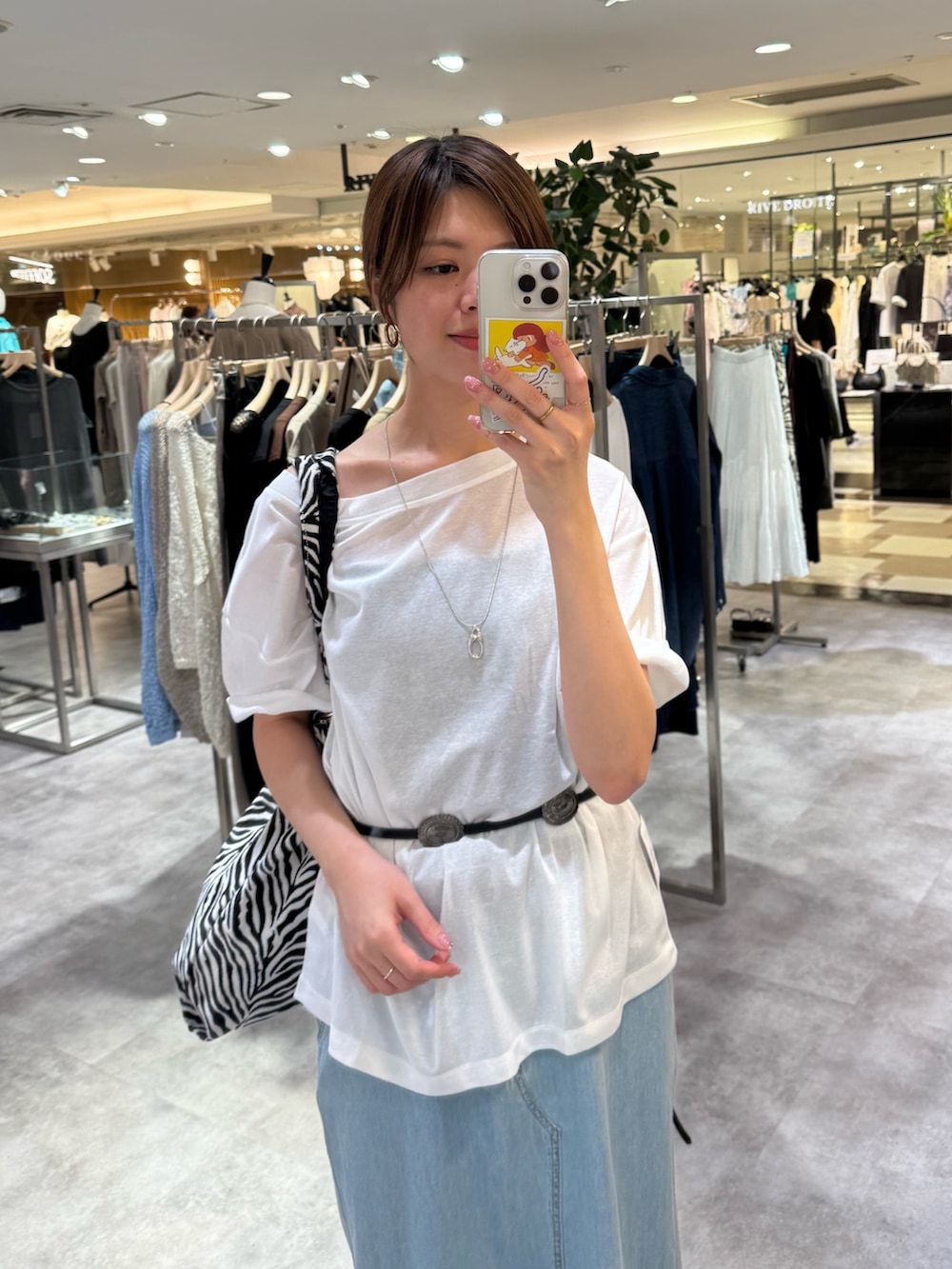 ホワイト系のTシャツ/カットソー、ブルー系のデニムスカート、ブラック系のサンダルを着用したレディースの夏コーディネートの2枚目の写真