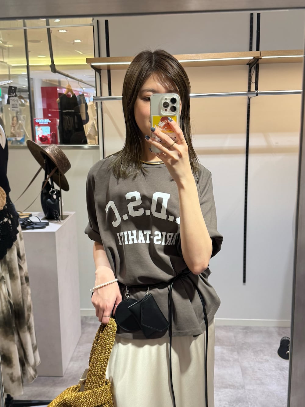 ブラウン系のTシャツ/カットソー、ベージュ系のスカート、ブラウン系のサンダルを着用したレディースの春コーディネートの3枚目の写真