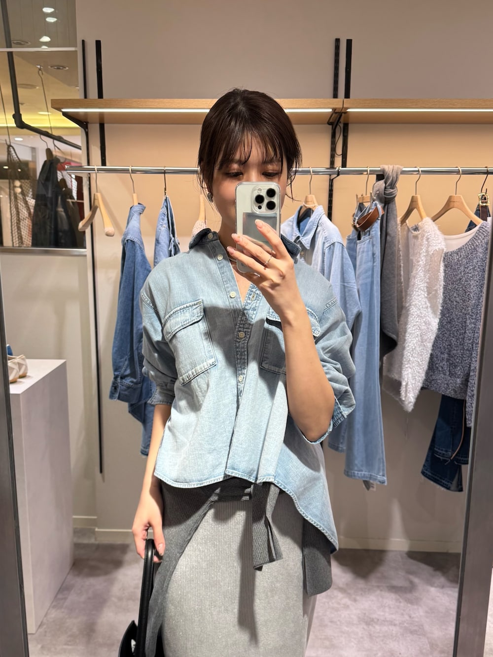 ブルー系のシャツ/ブラウス、グレー系のスカート、ブラック系のハンドバッグを着用したレディースの冬コーディネートの2枚目の写真