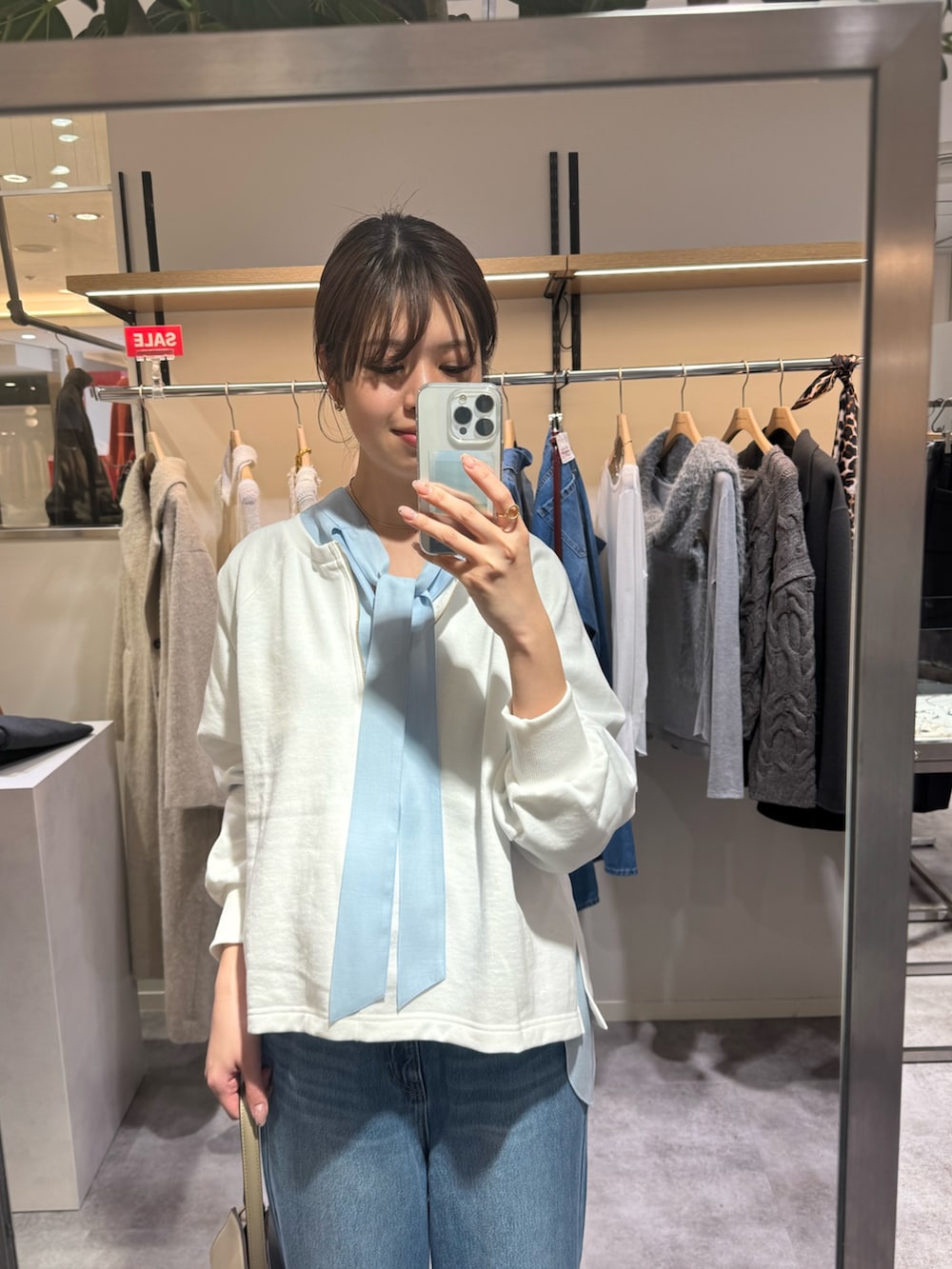 ブルー系のシャツ/ブラウス、ブルー系のデニムパンツ、ホワイト系のスウェットを着用したレディースの冬コーディネートの2枚目の写真